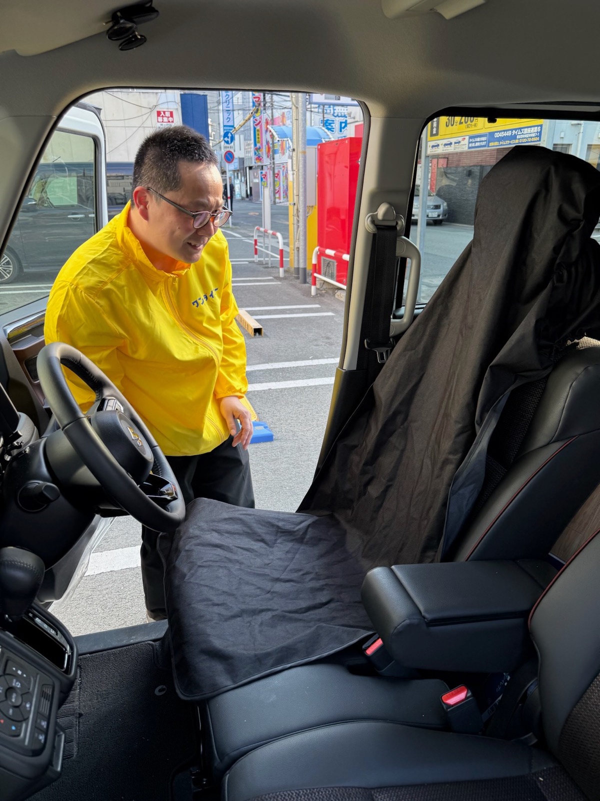 運転前にシートの養生をするワンダイコーのドライバー